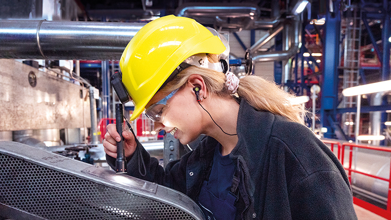 Junge Frau in Schutzkleidung bei der Arbeit