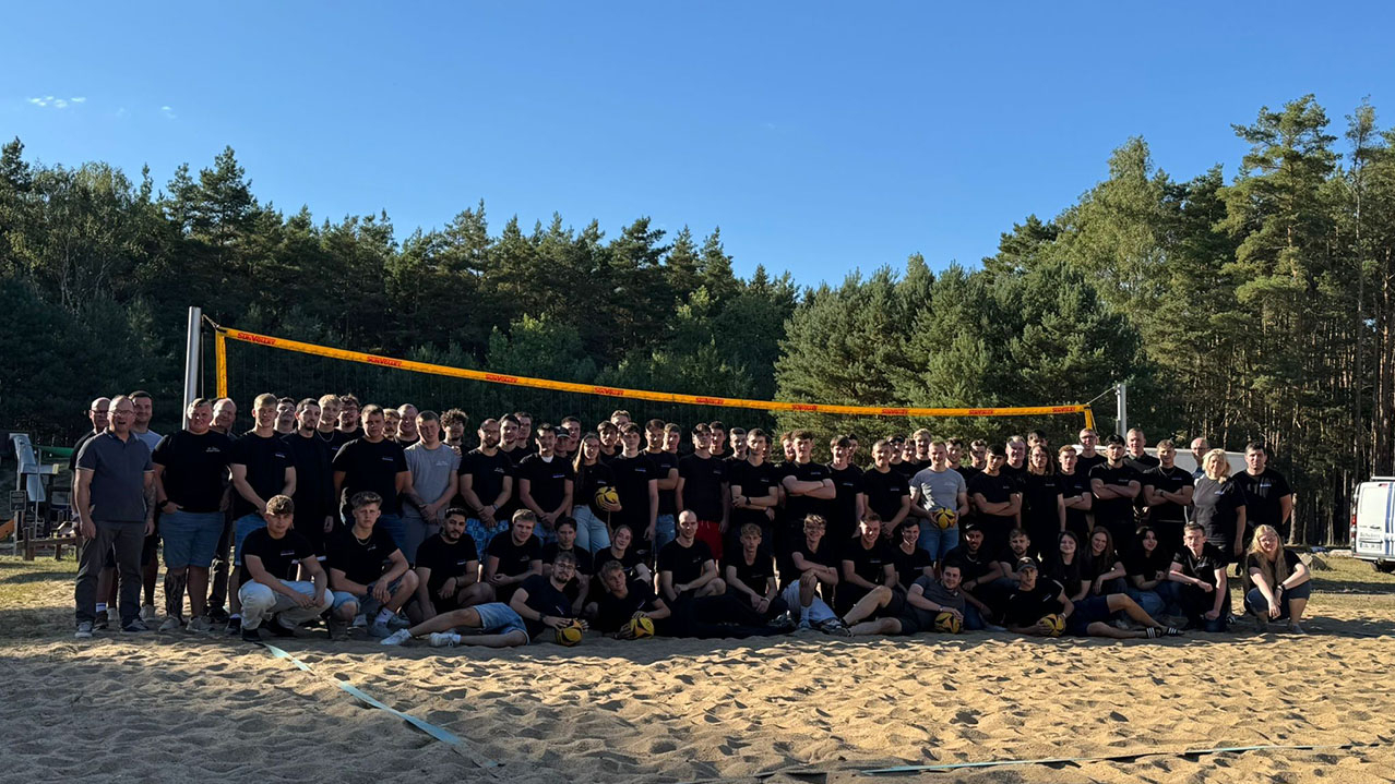 Gruppenbild auf einem Beachvolleyball-Feld
