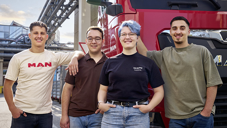 4 junge MAN Mitarbeitende vor einem MAN Truck