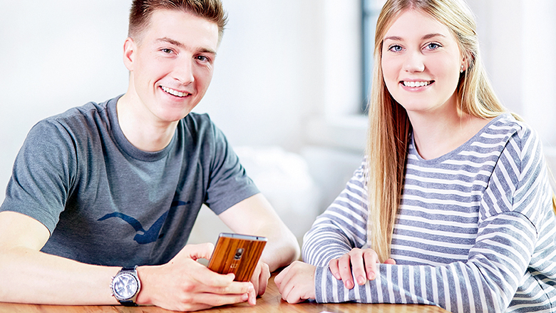 Zwei junge Menschen lächeln in die Kamera