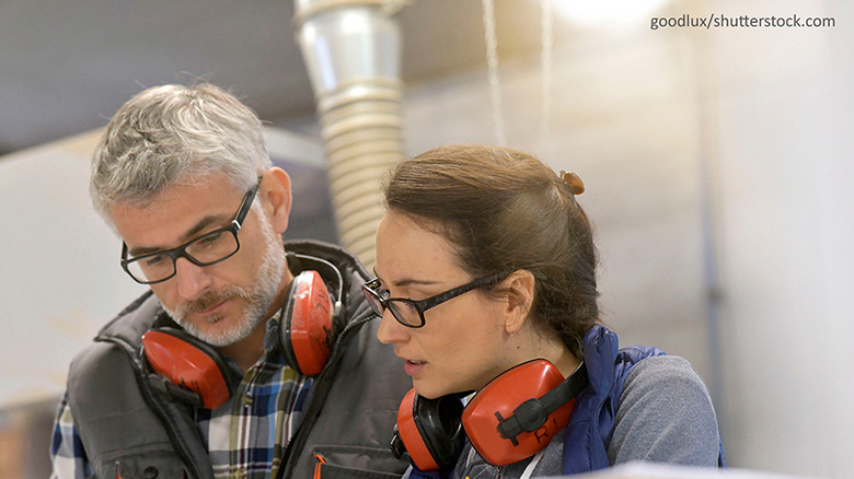 Handwerksmeister im Gespräch mit einer Mintarbeiterin