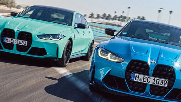 Ein blauer und ein türkiser BMW fahren auf einer Teststrecke
