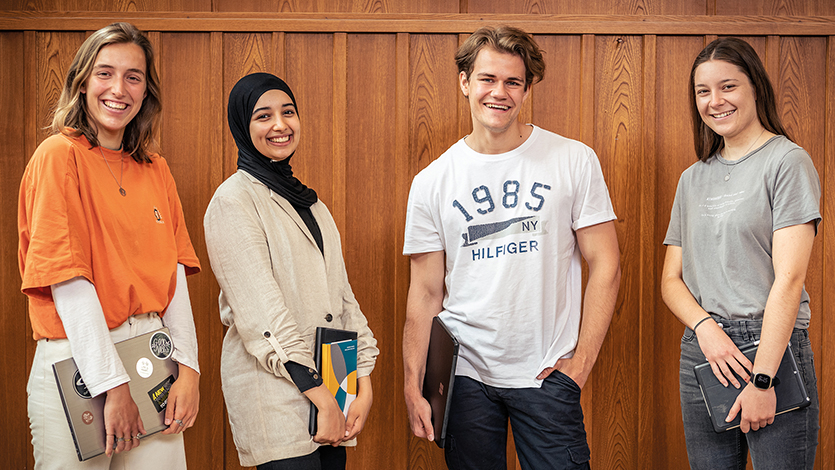 Gruppe vier junger Menscen lächeln in die Kamera