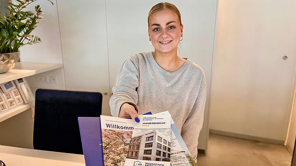 Dame am Empfang zeigt Broschüren