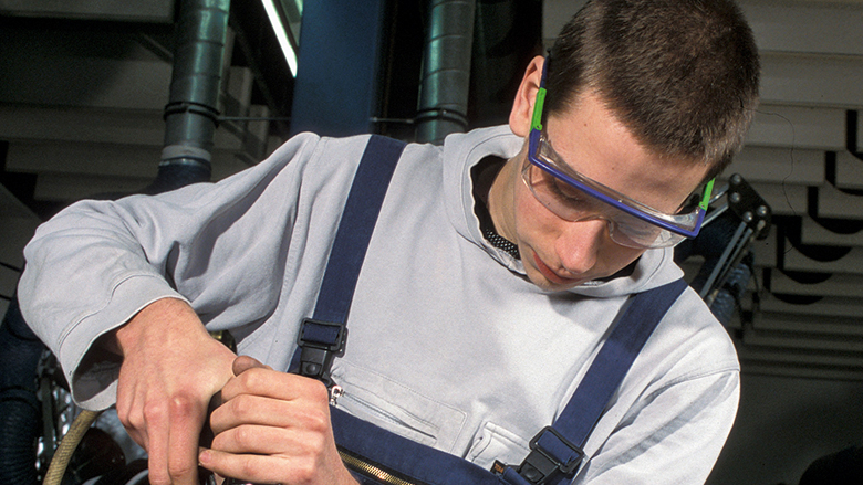 Azubi mit Schutzbrille arbeitet