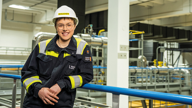 Junge Frau mit Arbeitskleidung und Helm