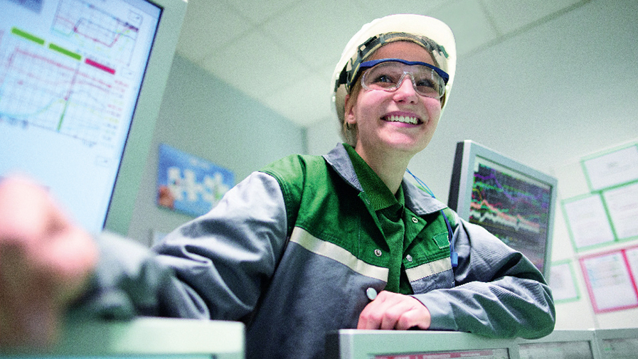 Junge Person in Arbeitskleidung lächelt