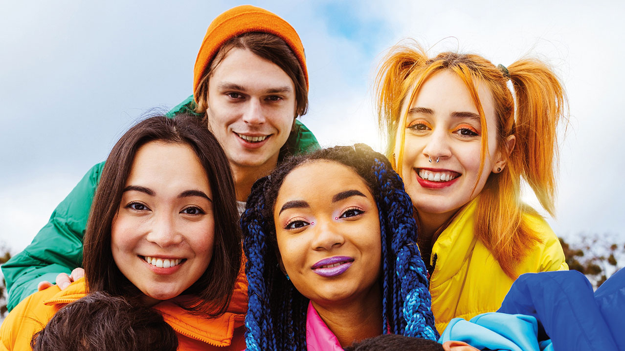 Gruppenbild von sehr bunt gekleideteten Jugendlichen verschiedener Kulturen