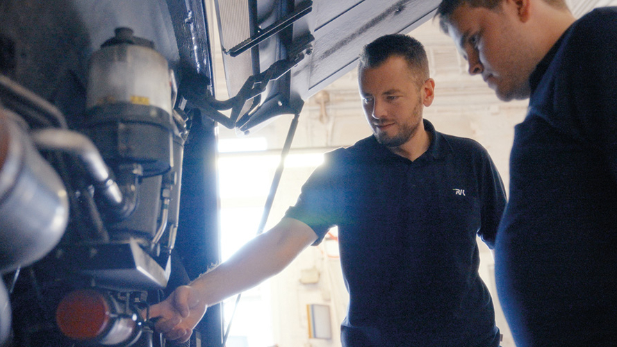 Zwei Männer diskutieren vor Fahrzeug 