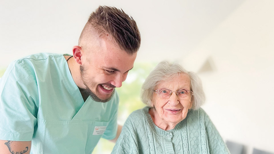 Pfleger und ältere Dame lächeln