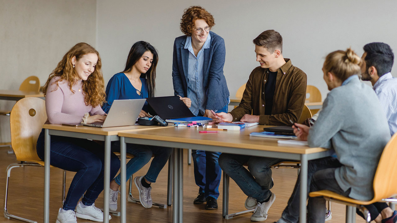 Studierende sitzen an einem Tisch