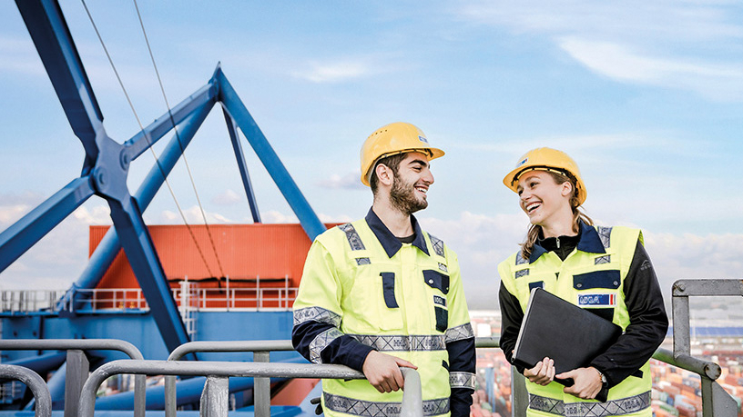 Zwei Mitarbeiter/innen auf einem Baugerüst