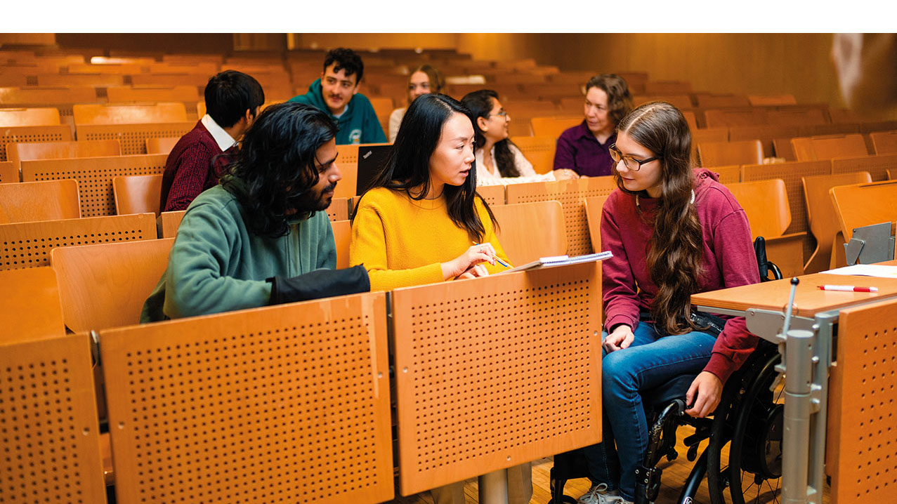 Personen verschiedener Nationen sitzen in einem Hörsaal