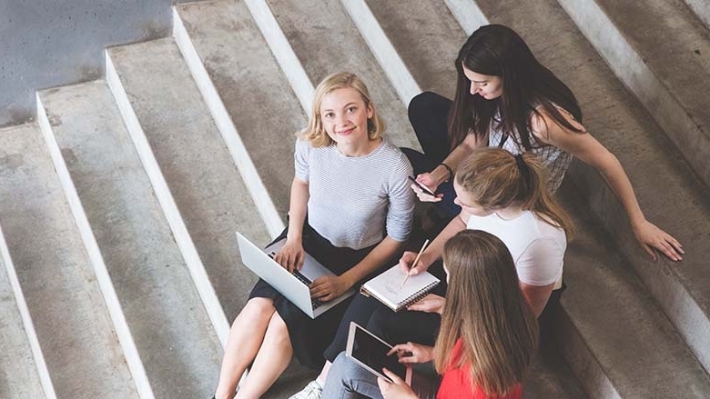 Vier junge Menschen sitzen auf einer Treppe