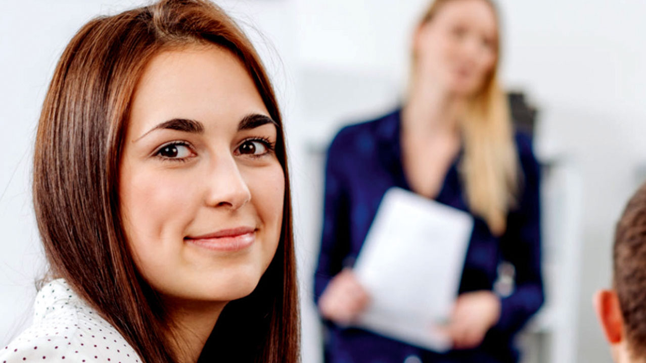 Eine Person blickt lächelnd in die Kamera.