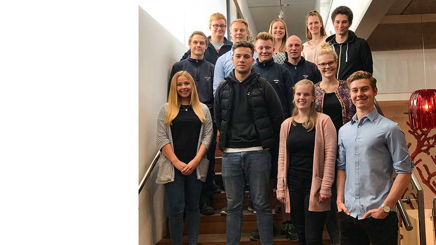 Junge Menschen stehen auf der Treppe und lächeln in die Kamera