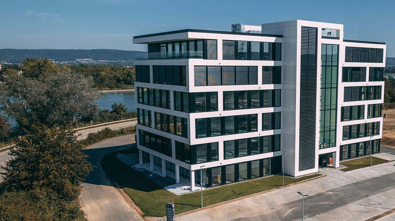 Gebäudeansicht, im Hintergund ein Fluss