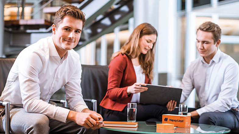 Drei junge Menschen sitzten an Tischen