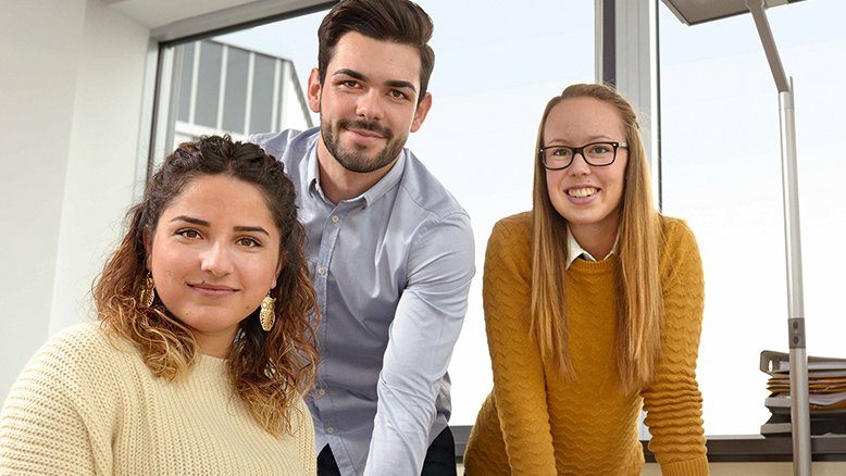 Kolleg/innen lächeln in die Kamera