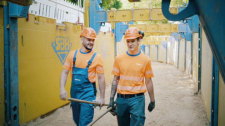 Zwei Menschen mit Helm auf einer Baustelle