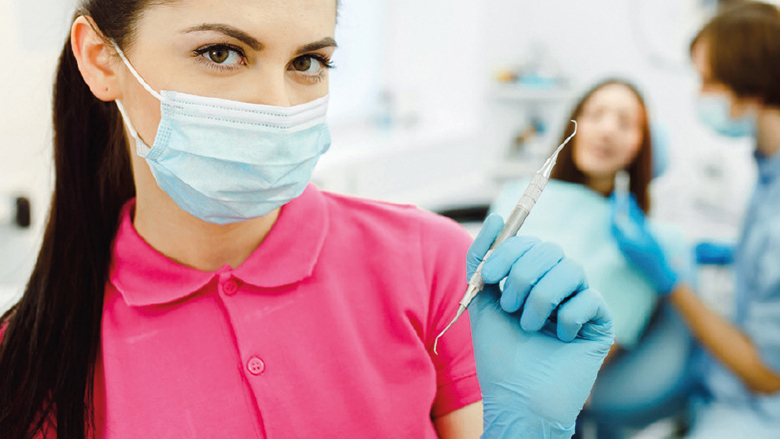 Zahnmedizinische Fachangestellte mit Mundschutz und Werkzeug im Hintergrund Zahnarzt mit Patientin darunter der Spruch Die Ausbildung mit Biss!