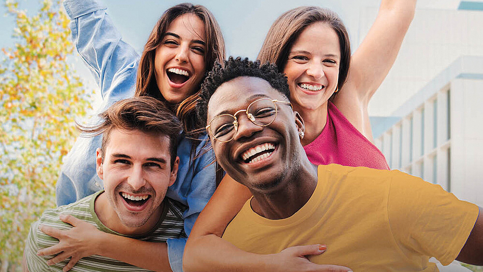 Vier junge Menschen lachen in die Kamera