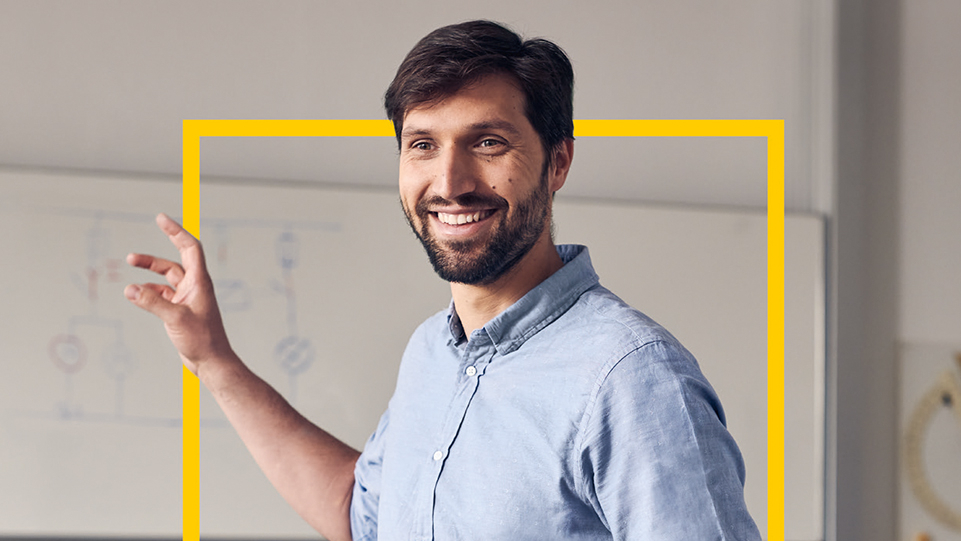 Man steht vor einer Tafel und erklärt etwas