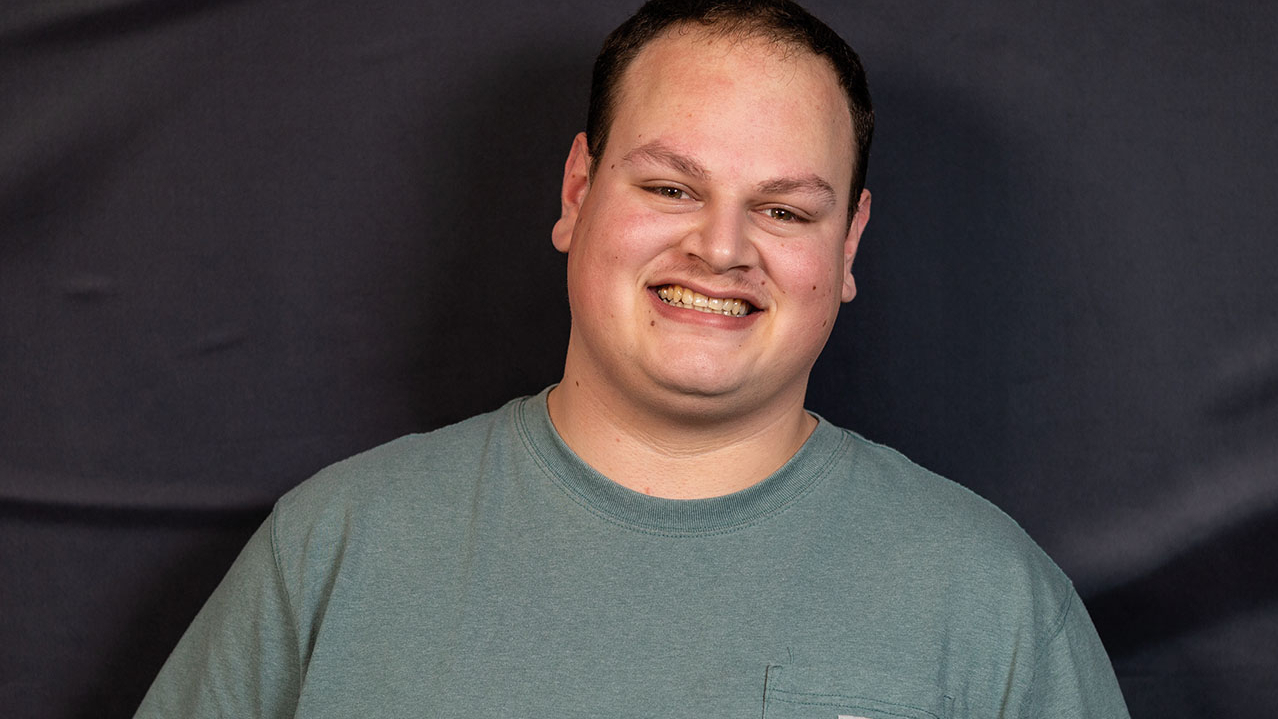 Stattlicher junger Mann in grauem T-Shirt