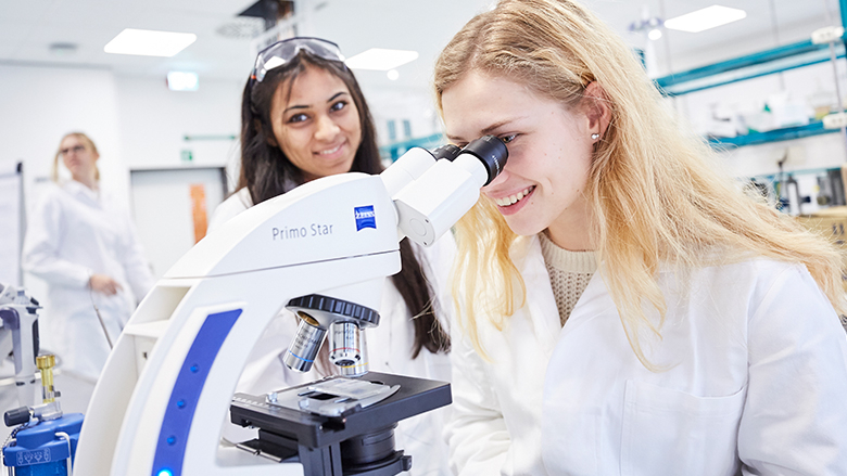 Zwei junge Menschen im Labor am Mikroskop