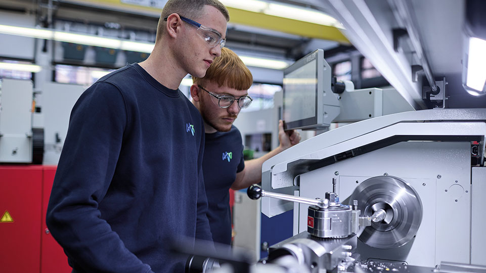 zwei junge Männer stehen vor einer Maschine