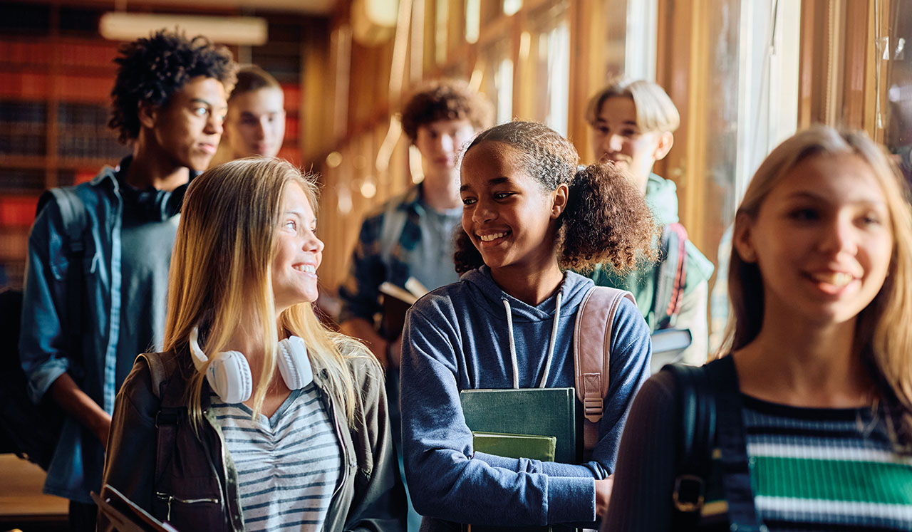 Mehrere Schüler/innen unterhalten sich in einem Flur