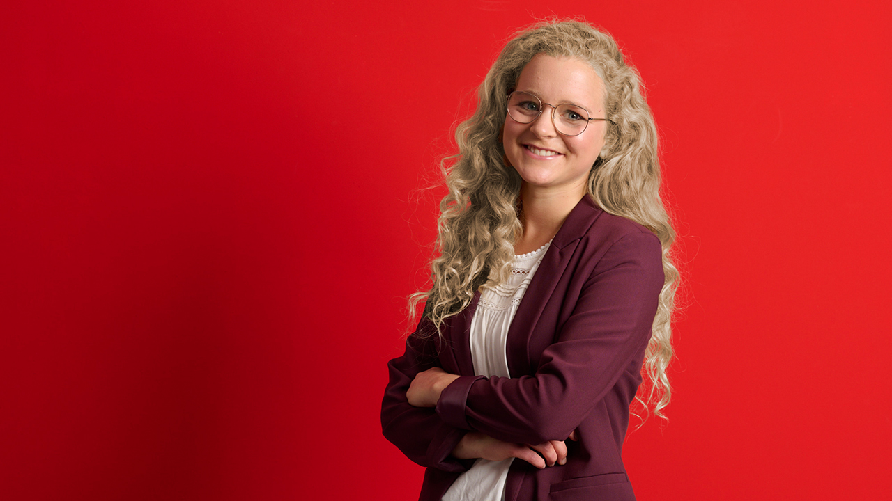 Porträt einer Frau vor einem einfarbig rotem Hintergrund