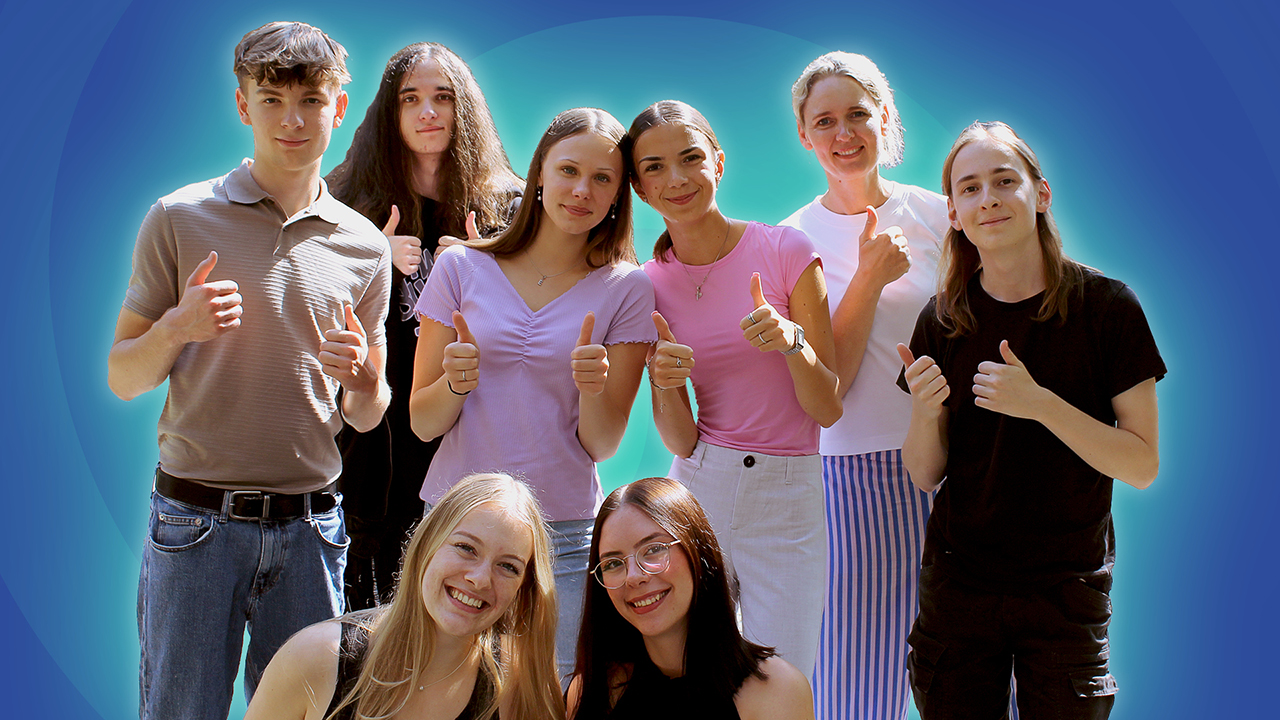 Gruppenbild von jungen Menschen vor blauem Hintergrund