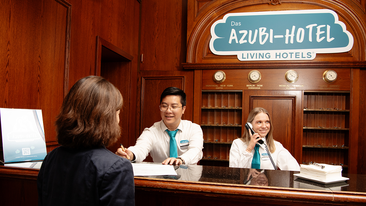 Eine Hotelrezeption mit zwei Mitarbeitern hinter dem Tresen