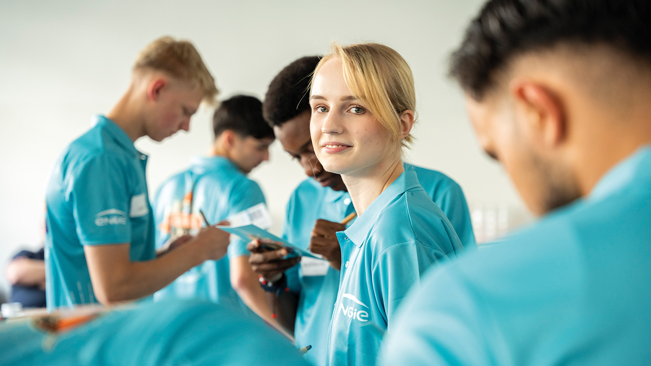 Junge Mitarbeitende in Arbeitskleidung 