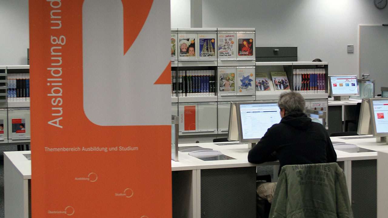 Person am Computer in den Räumen der Agentur für Arbeit