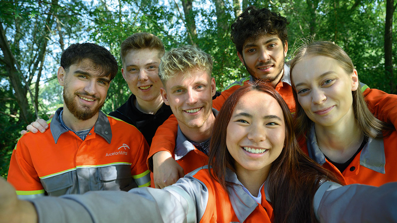 Selfie von jungen Mitarbeitenden der ArcelorMittal Bremen GmbH in Arbeitskleidung