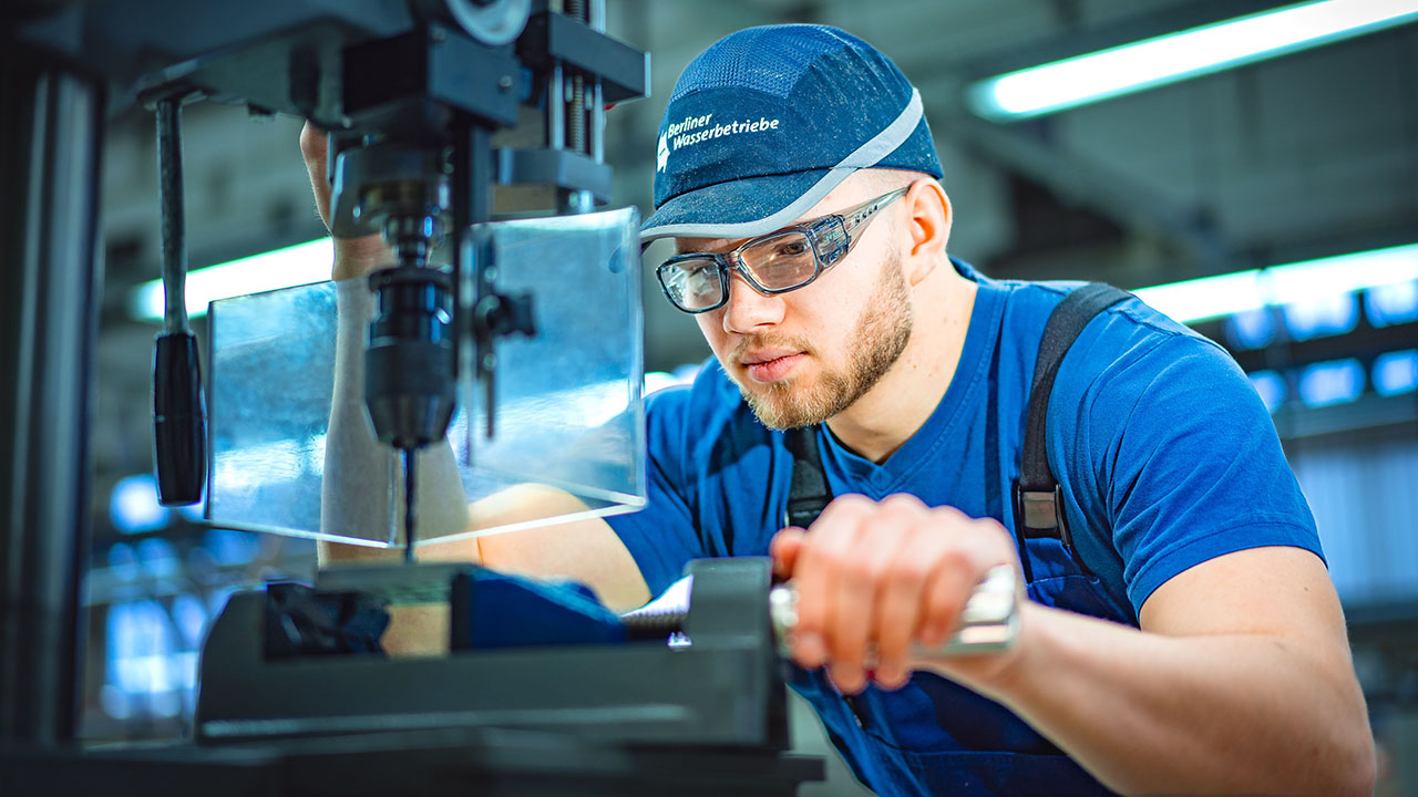 Auszubildender im Bereich Metall/-Elektrotechnik arbeitet an einer Maschine