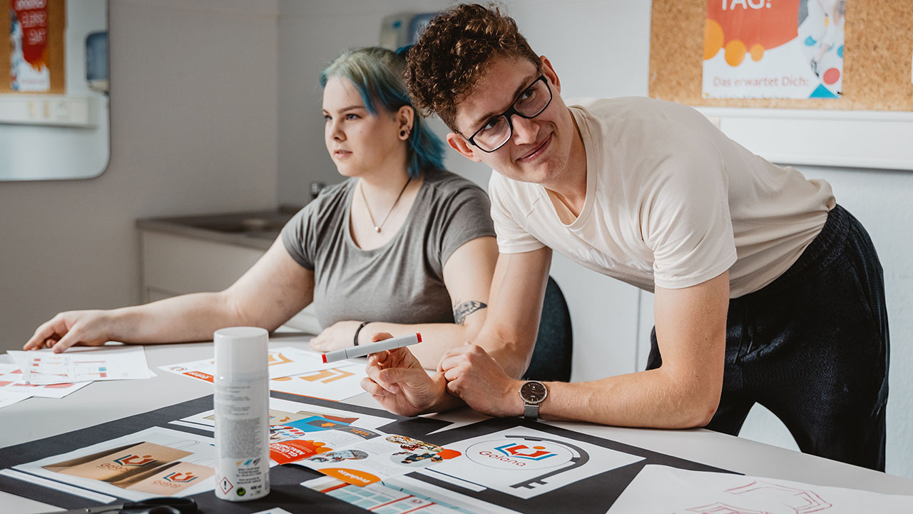 Zwei junge Menschen arbeiten kreativ am Schreibtisch