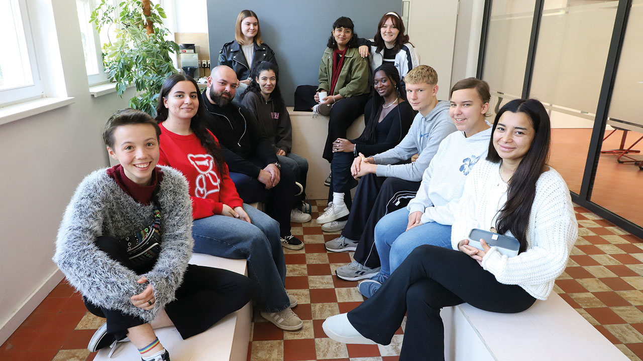 Eine Gruppe mit jungen Menschen schaut in die Kamara