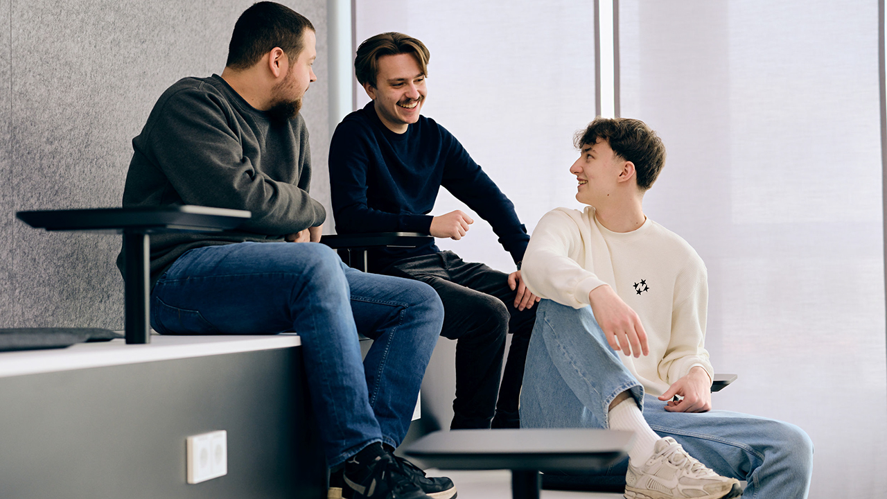 Drei junge Menschen sitzen gemeinsam auf einer Treppe