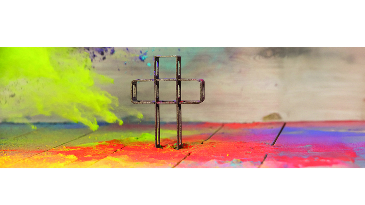 Bunter Hintergrund. In der Mitte steht ein Kreuz aus Metall