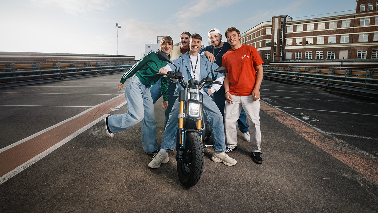 Junge Menschen mit einem Roller auf einer ruhigen Straße