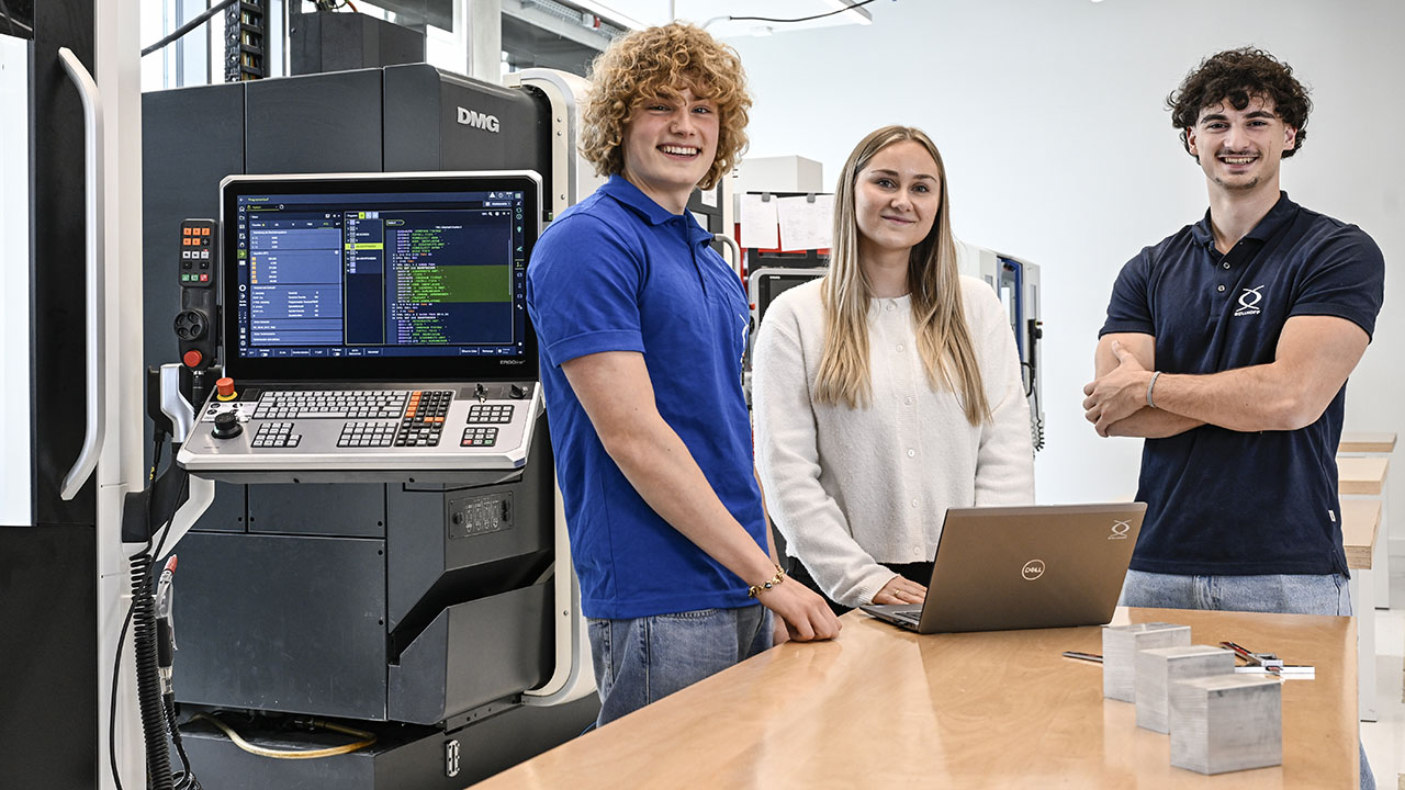 Drei Personen vor Laptop