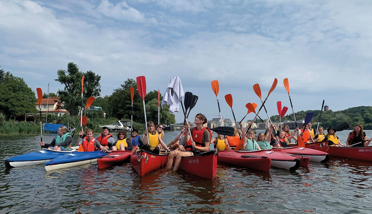 Gruppenbild in Kanus auf einem See.