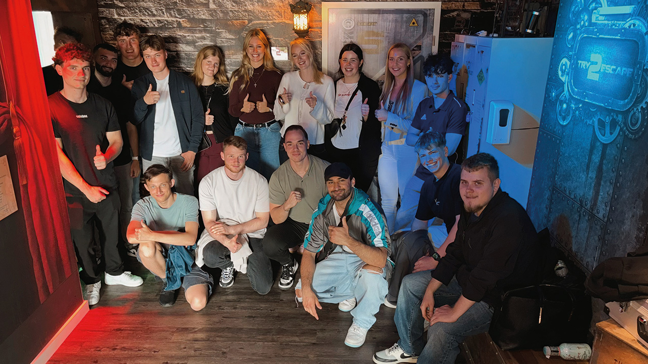 Gruppe von jungen Menschen, im Halbkreis, lächeln in die Kamera