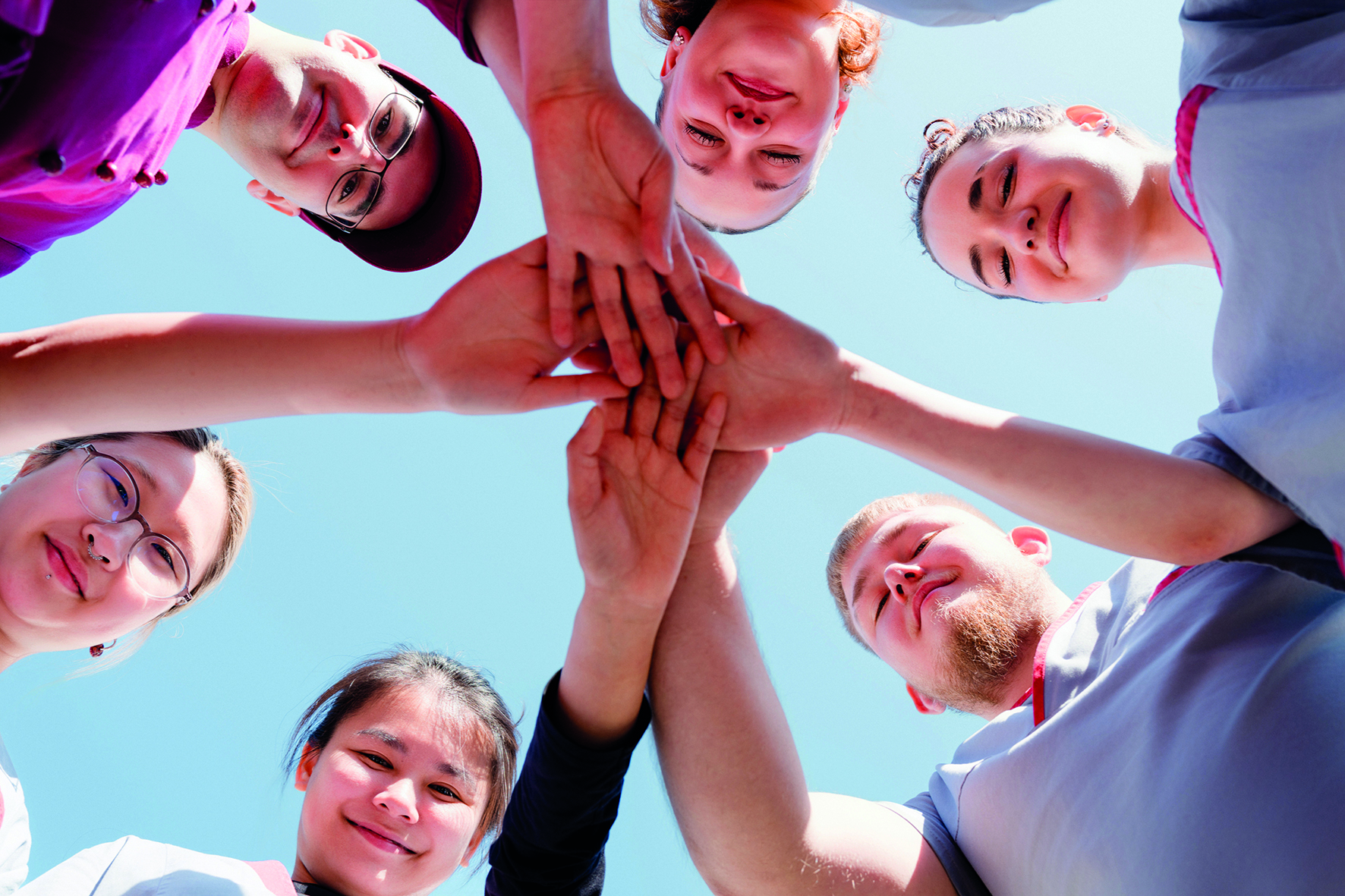Menschen halten alle ihre Hände in die Mitte