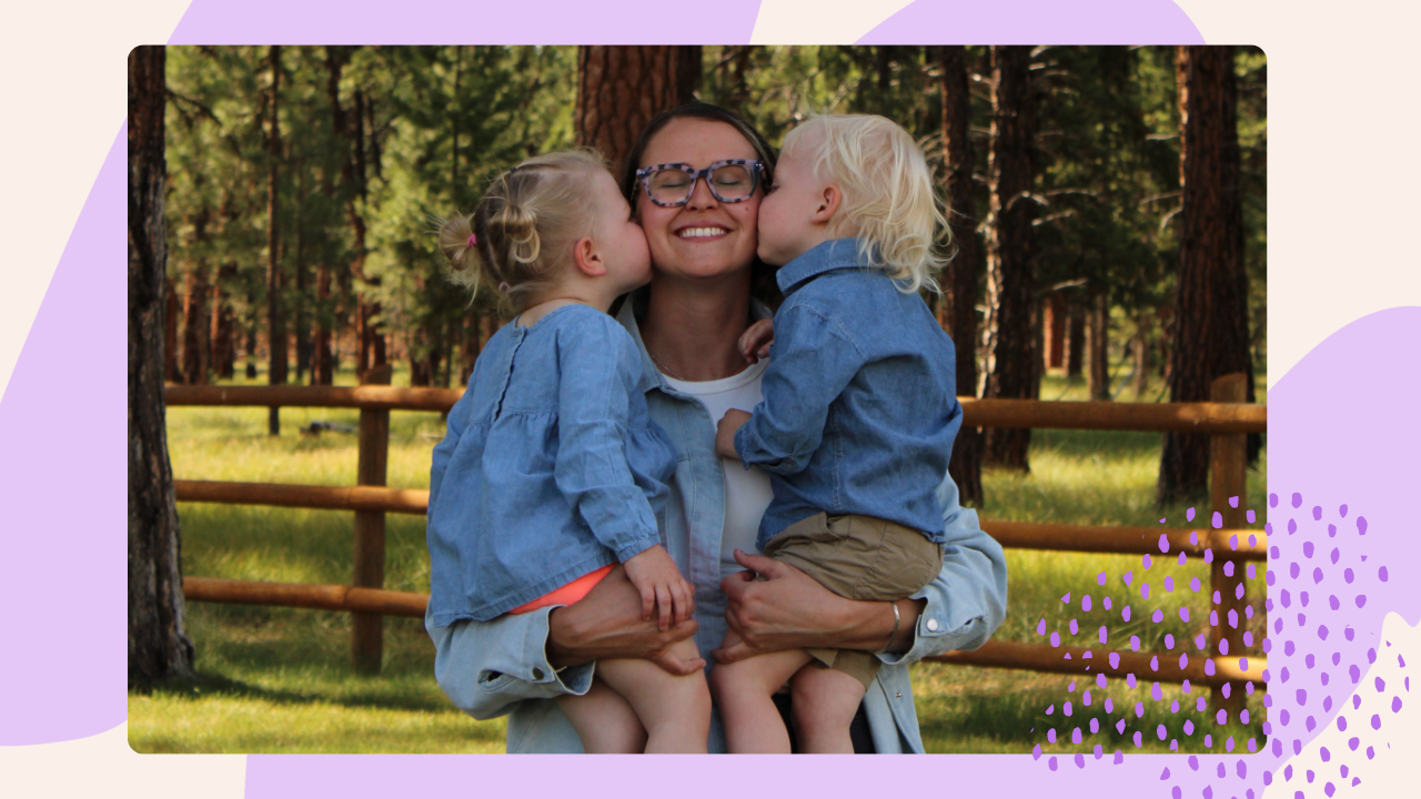 Au-pair mit zwei Kindern im Arm in der Natur