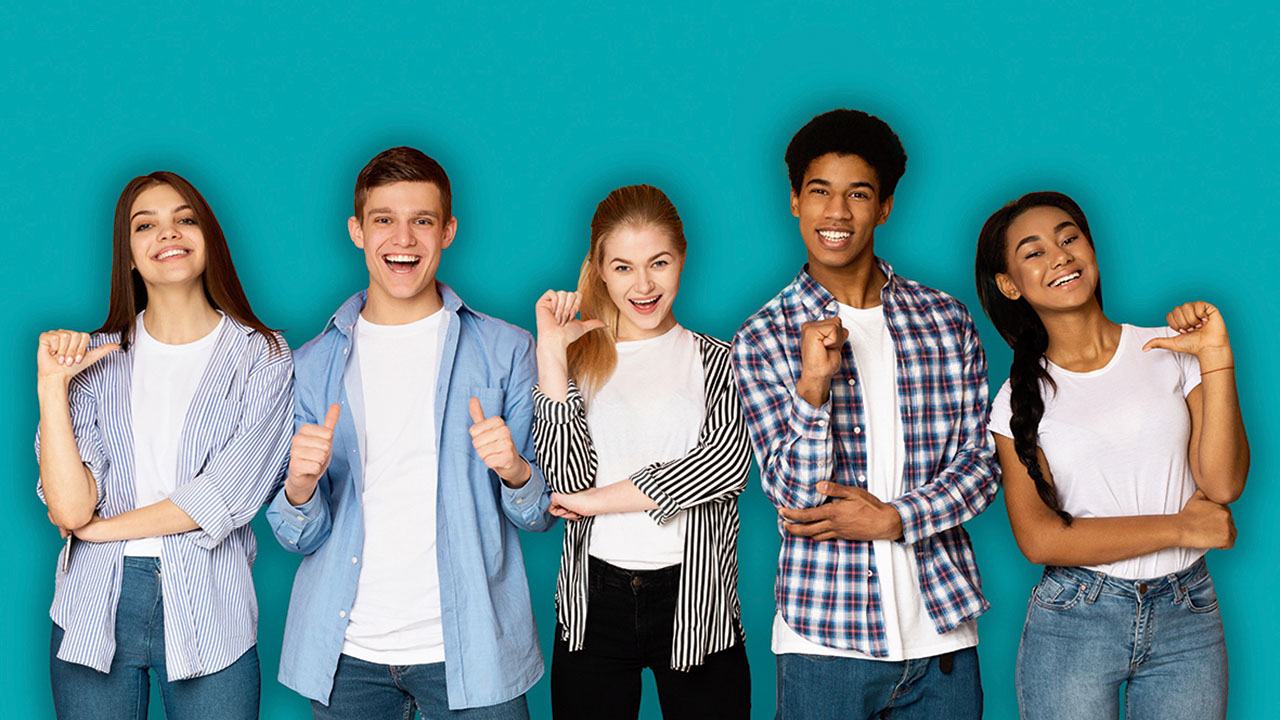 Fünf junge lächelnde Personen vor einem türkisfarbenen Hintergrund, die mit dem Daumen auf sich zeigen