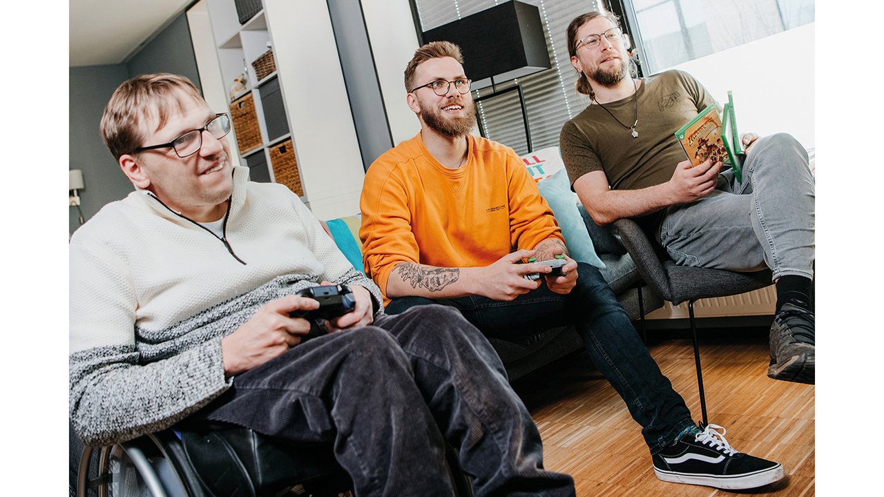 Drei Männer sitzen gemeinsam in einem Raum